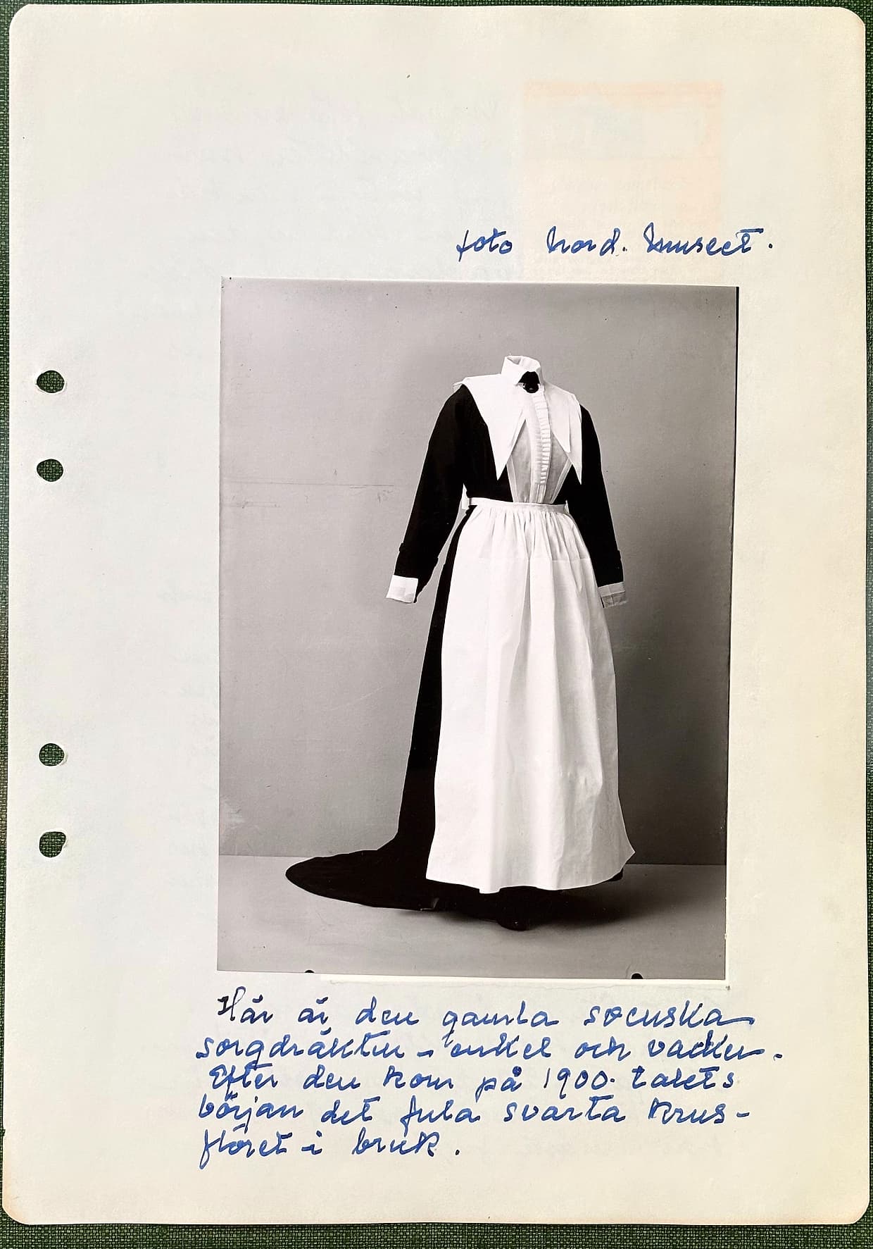 Fotograferad dagbokssida 125. Överst en handskriven rad, därunder ett fotografi av en svart sorgdräkt med hög krage, stor vit krage, vitt förkläde och släp, uppsatt på docka, och underst fem rader handskrift. Sidans text är återgiven under bilden.