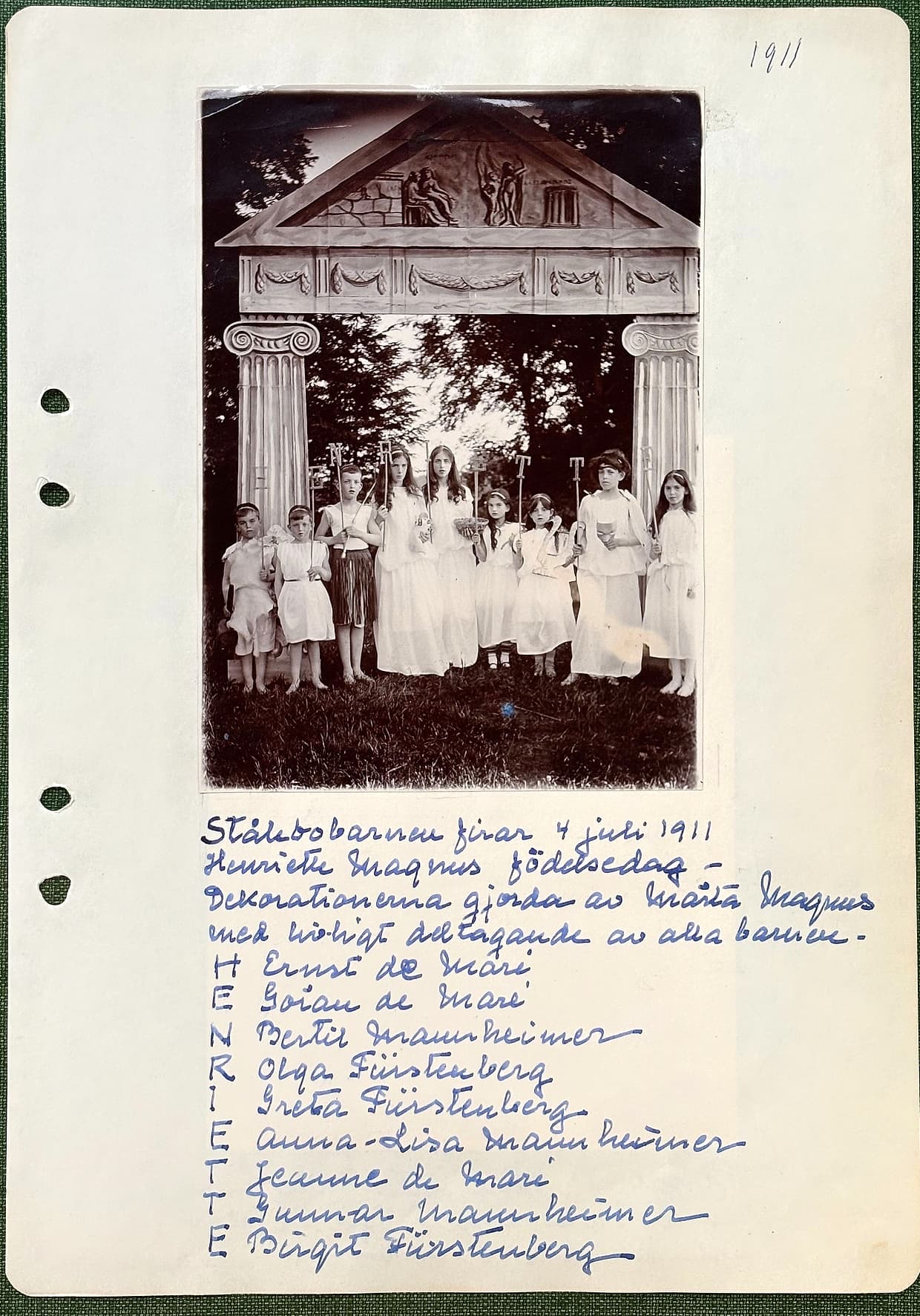 Fotograferad dagbokssida 173. Foto av nio barn i vitt med facklor och ljus framför en målad grekisk tempelfasad med joniska kolonner och frontongrupp. Sidans text är återgiven under bilden.