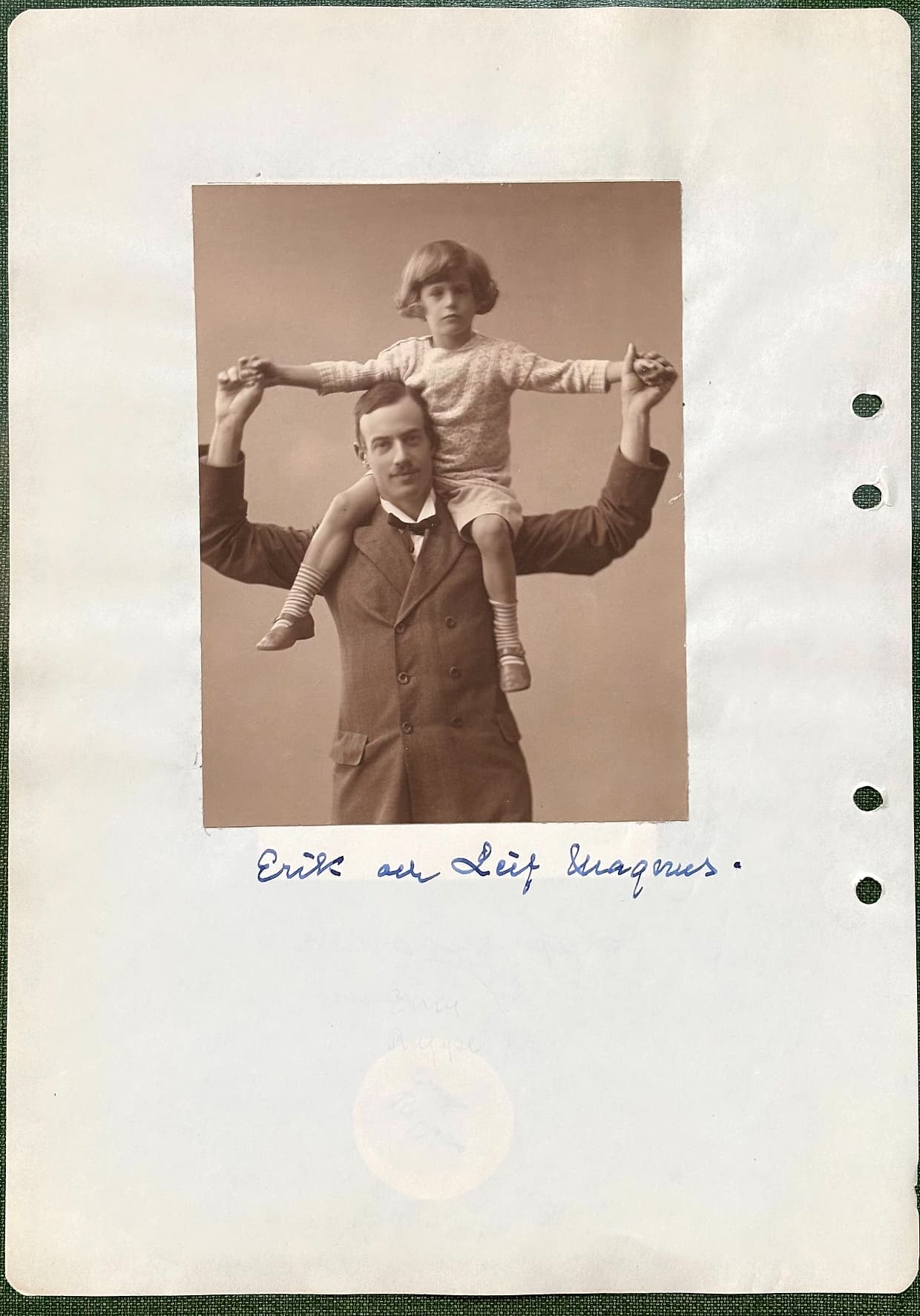 Fotograferad dagbokssida 206. Ateljéfotografi av en man i kostym med ett barn på axlarna; de håller varandras utsträckta händer. Bildtext: 'Erik och Leif Magnus'.