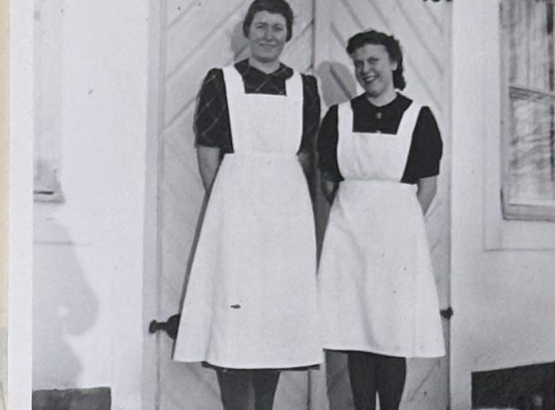 Husorna på Landsjö, Elsa och Dagmar, i förkläden på en trappa.